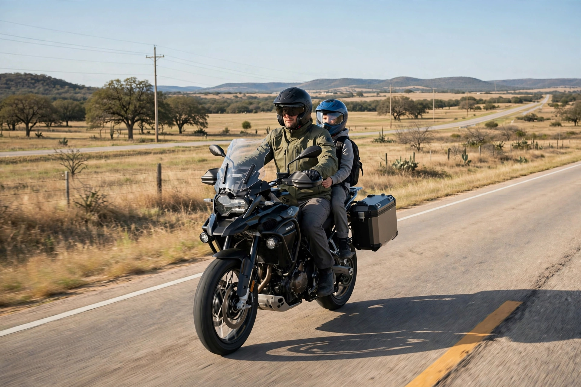 Motorcycle rider with a helmeted young passenger on a Texas road