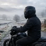 Rider wearing a sealed winter motorcycle helmet on a cold morning road