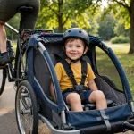Child wearing a helmet sitting in a bike trailer behind a parent